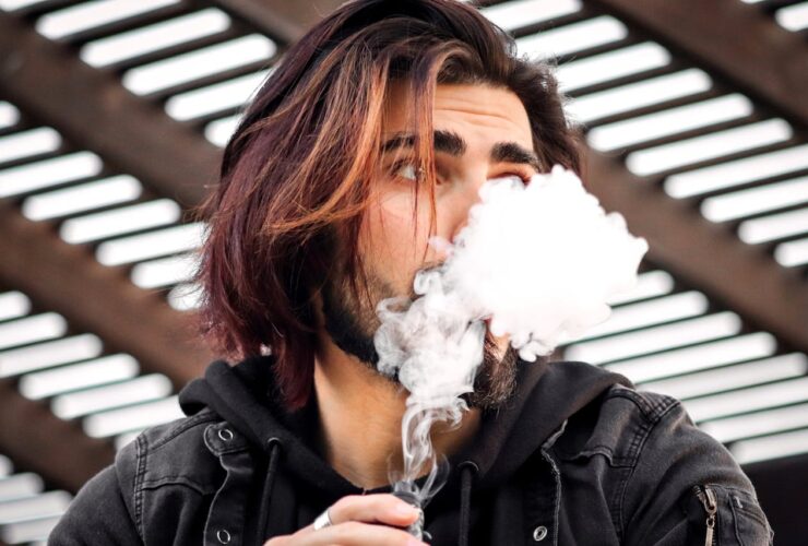 un homme qui fume avec une cigarette électronique