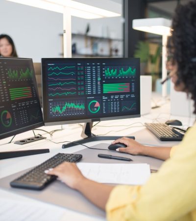 une personne avec 2 écrans qui analyse des stats